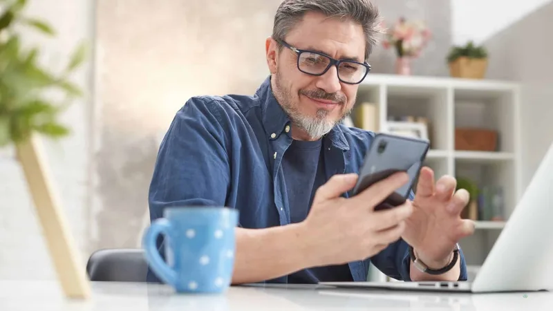 Man checking his phone while relaxing at home