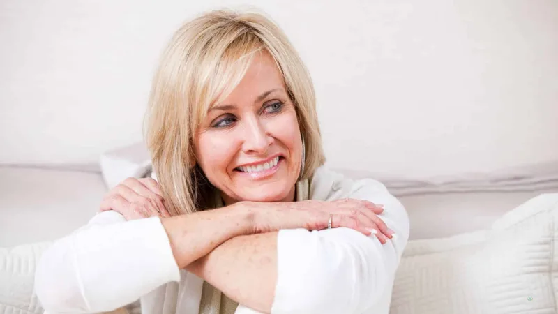 Woman smiling while relaxing on a couch at home